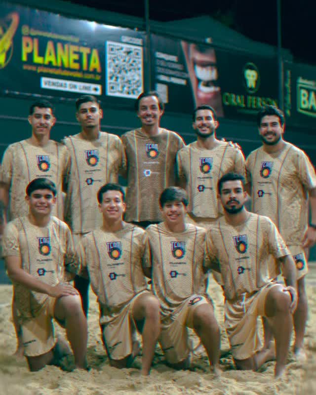 Time de futevôlei uniformizado na quadra à noite