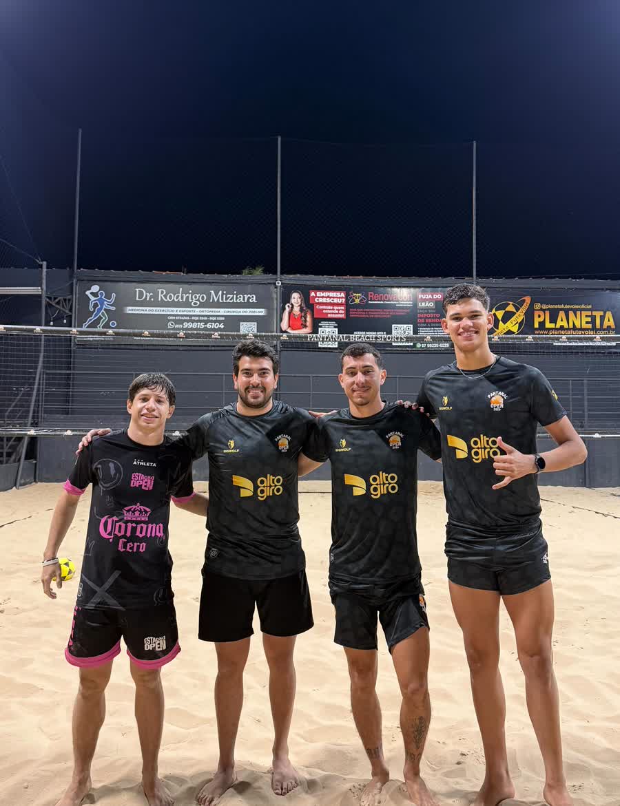 Atletas de futevôlei na quadra iluminada à noite