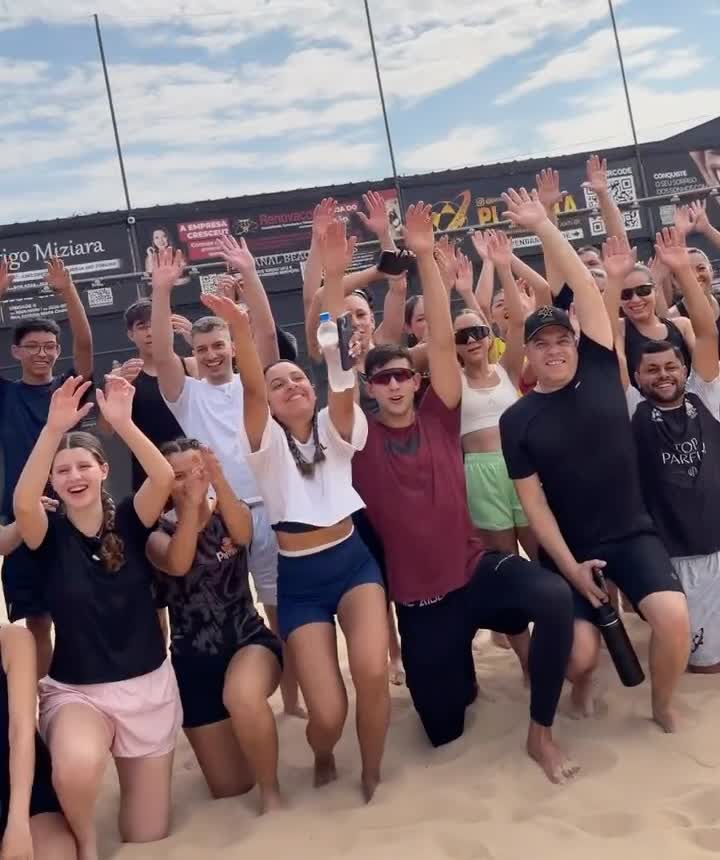 Turma de vôlei de praia comemorando na areia